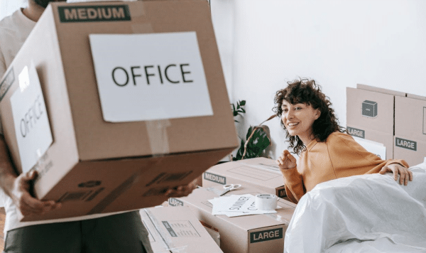 Man carrying office-labeled cardboard box