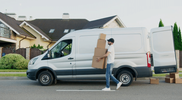 Professional movers carrying boxes and white van